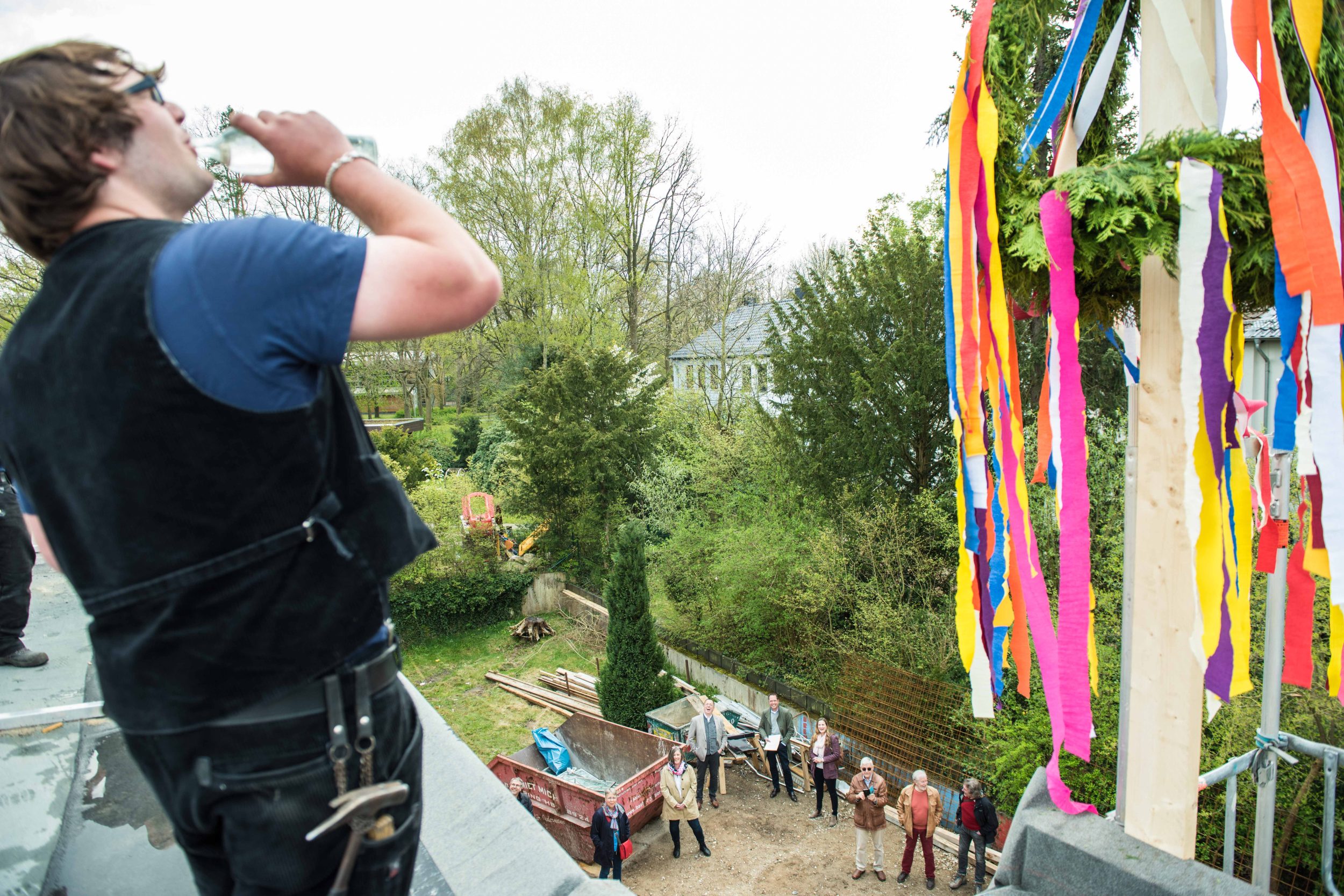 Zimmermann Tim Seedorf trinkt aus der Richtfestflasche