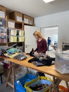 Eine Frau sortiert Kleidungerspenden.