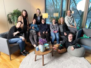 Eine Gruppe von Menschen mit geistiger Beeinträchtigung sitzt auf einem Sofa, gemeinsam mit Moderator Ansgar Langhorst