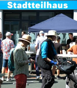 Viele Menschen bei Sonnenschein vor dem Stadtteilhaus.