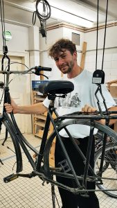 Ein Mann arbeitet an einem Fahrrad in einer Werkstatt
