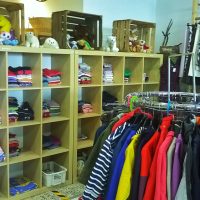 Eine Regalwand und ein Kleiderständer eines Secondhand-Ladens